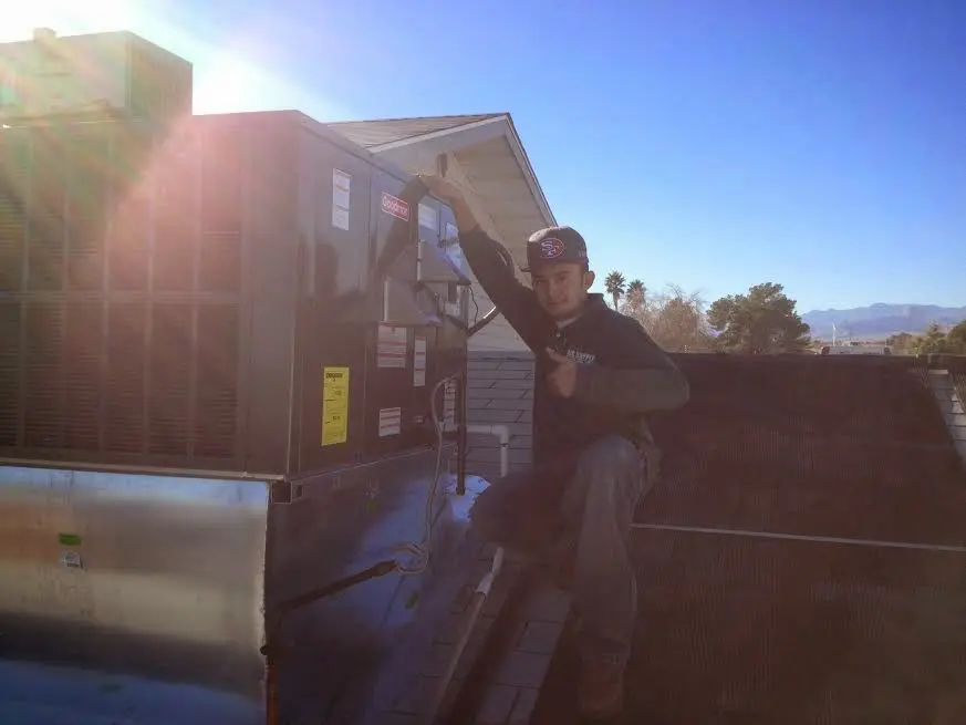 HVAC technician performing Boiler Repair on a rooftop unit in Ozark